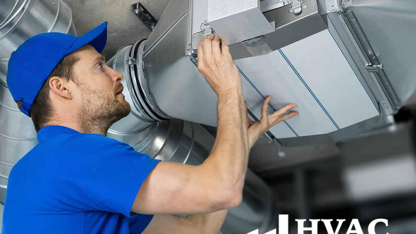 An HVAC technician in a blue uniform working on air ducts in an industrial setting, with the HVAC Metal Home LLC logo visible.