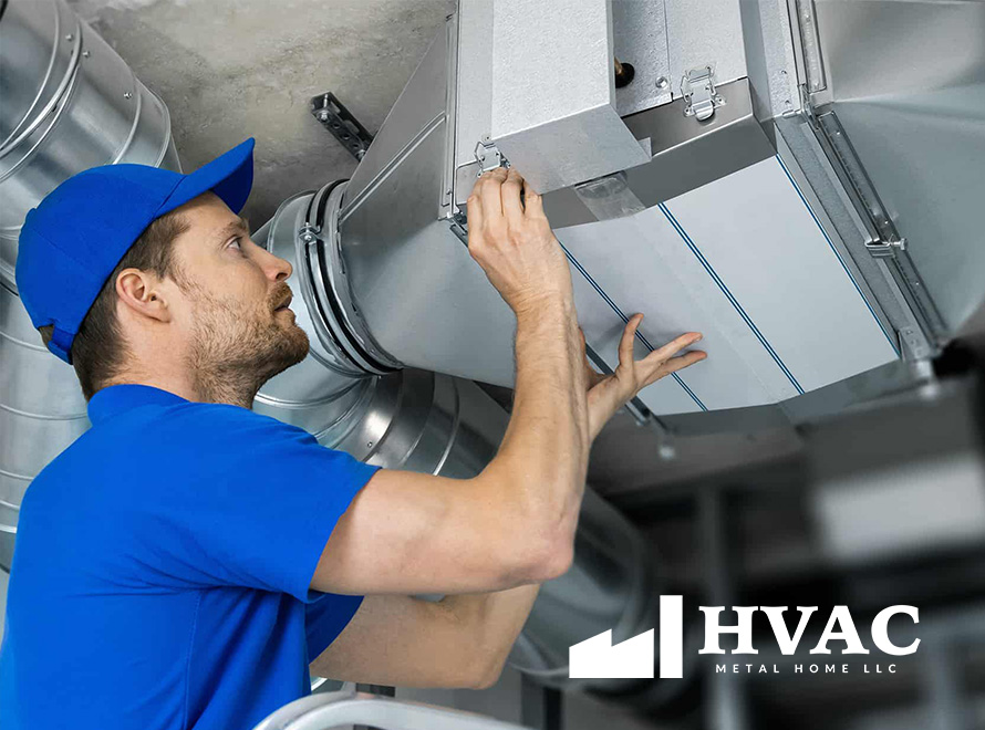 An HVAC technician in a blue uniform working on air ducts in an industrial setting, with the HVAC Metal Home LLC logo visible.